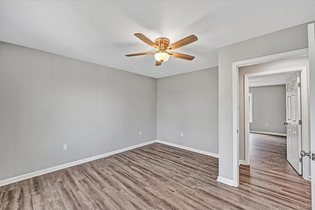 a view of a room with wooden floor and a ceiling fan