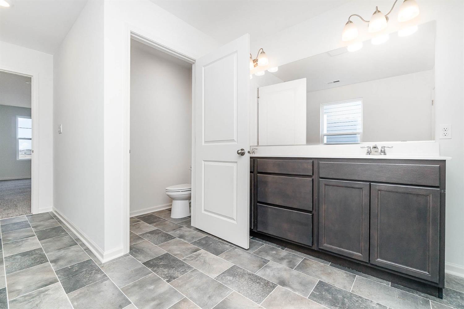 10354 Bryan Place Crown Point, IN 46307 - Photo 16 of 35 a bathroom with a sink a toilet and a mirror