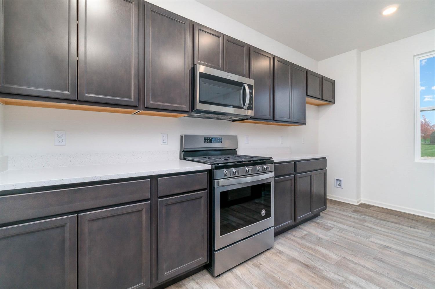 10354 Bryan Place Crown Point, IN 46307 - Photo 8 of 35 a kitchen with stainless steel appliances granite countertop a stove a microwave and a sink