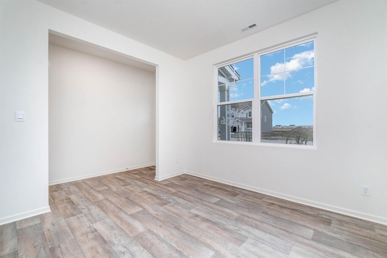 10354 Bryan Place Crown Point, IN 46307 - Photo 10 of 35 a view of an empty room with wooden floor and a window