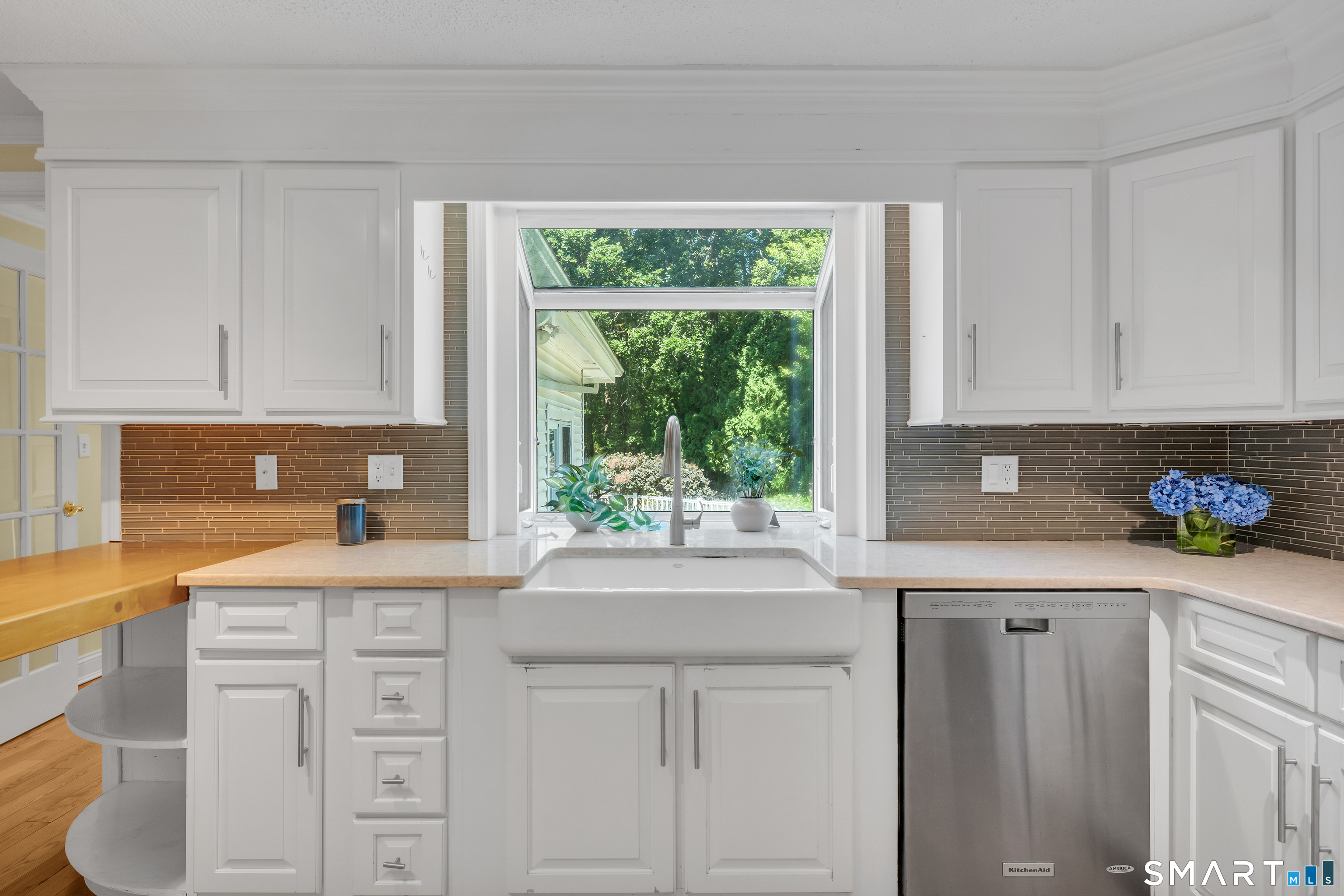 110 Nut Plains Road Guilford, CT 06437 - Photo 16 of 40 Quartz counters, glass tile backsplash, and a garden window made for fresh herbs.