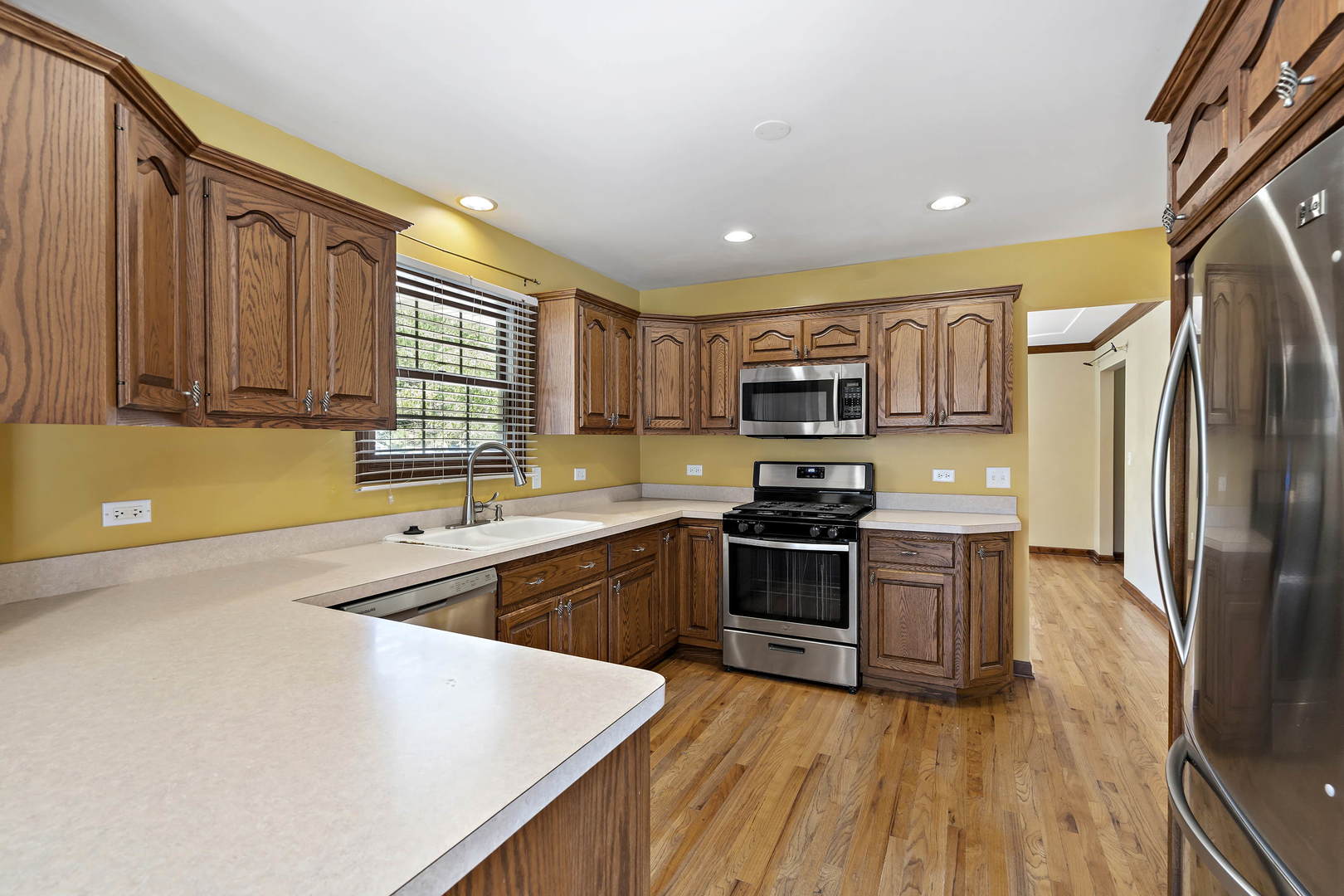 23501 West McClintock Road Channahon, IL 60410 - Photo 8 of 19 a kitchen with stainless steel appliances granite countertop a stove top oven a sink dishwasher a refrigerator and cabinets with wooden floor