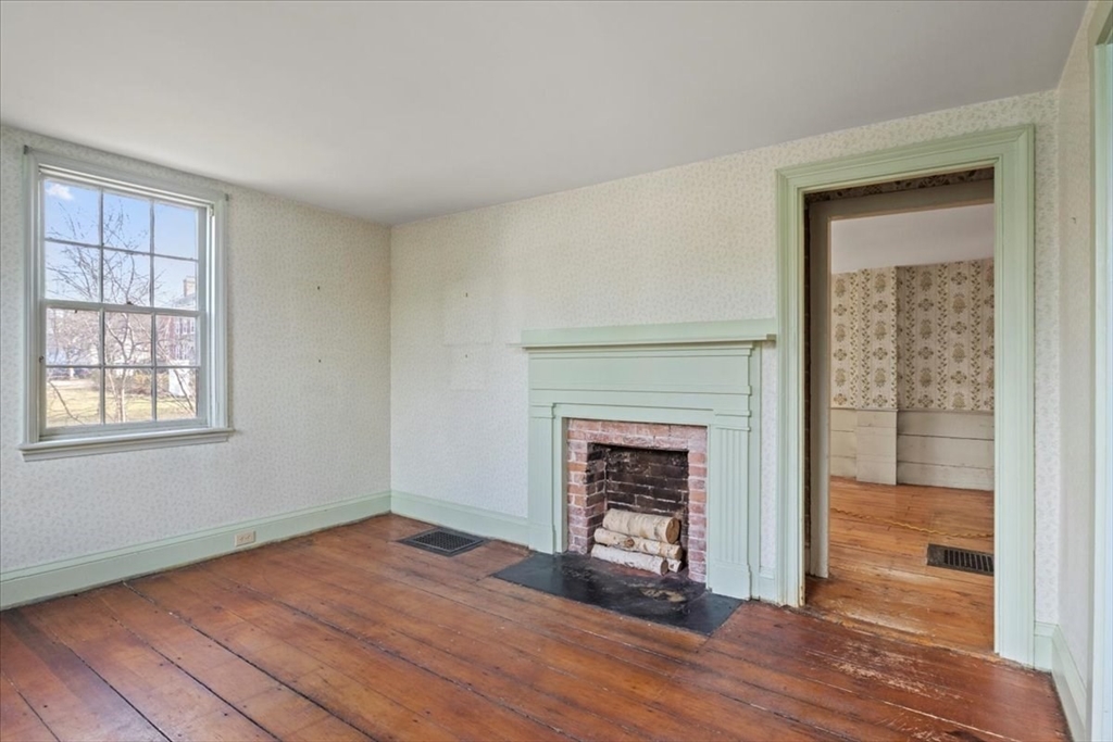 600 High Street Westwood, MA 02090 - Photo 3 of 27 a view of an empty room with wooden floor fireplace and a window