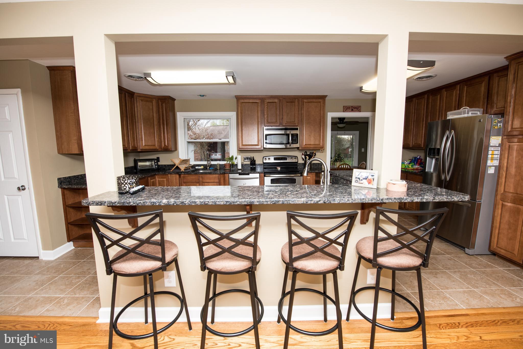 604 Bryan Point Road Accokeek, MD 20607 - Photo 5 of 29 a kitchen with stainless steel appliances granite countertop table chairs sink and cabinets