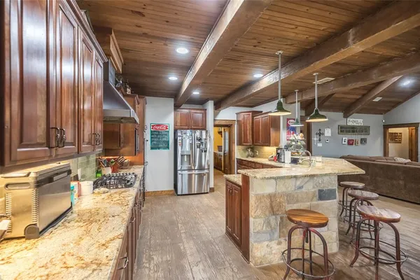 a kitchen with a stove a refrigerator and wooden cabinets