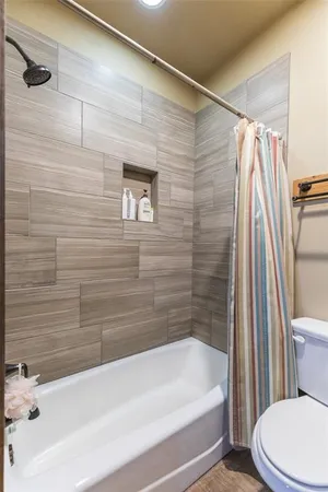 a bathroom with a granite countertop sink and a toilet