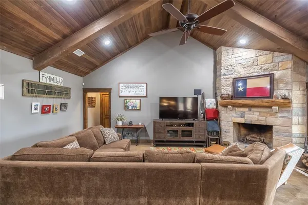a living room with furniture a flat screen tv and a fireplace