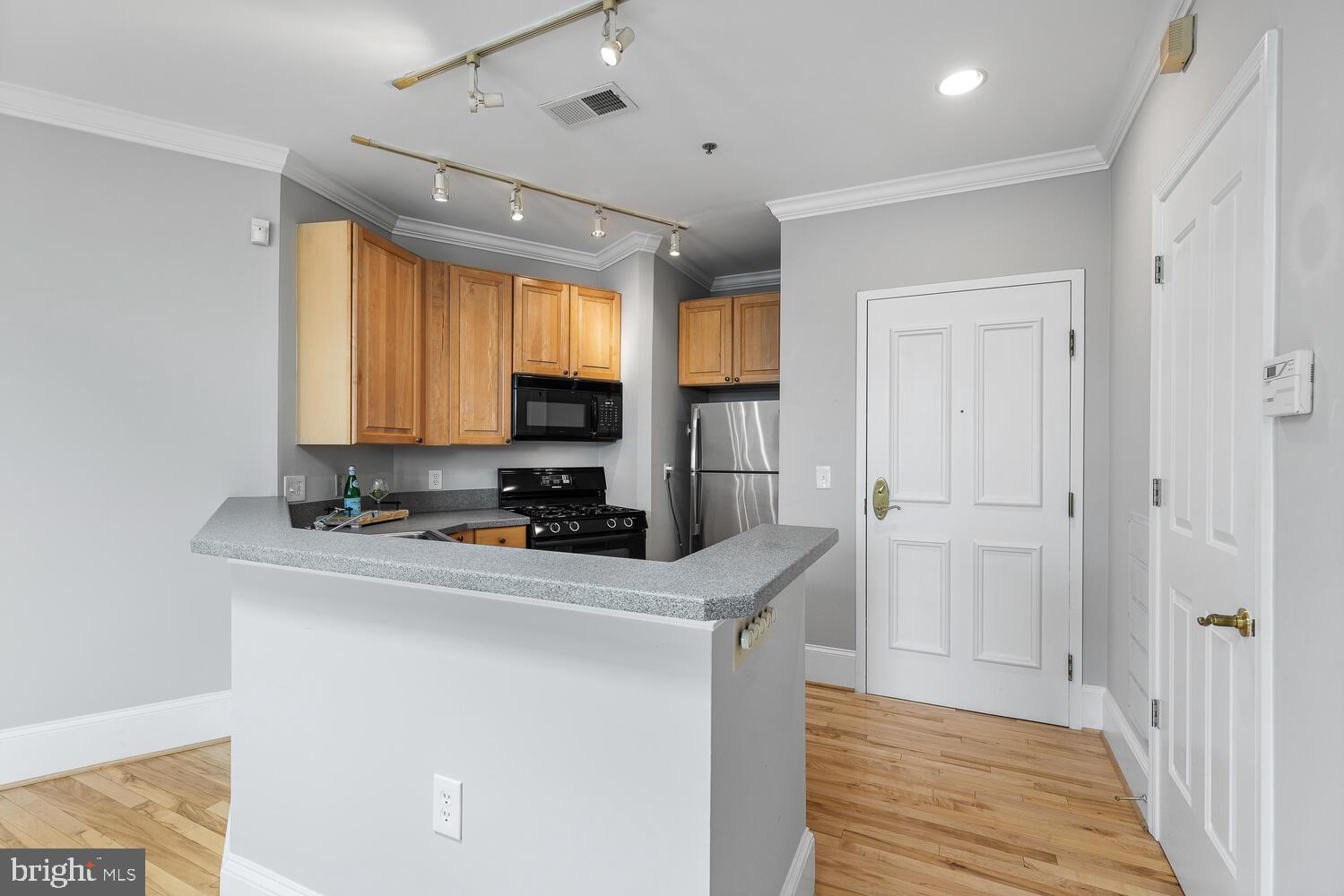 20 Logan Circle Northwest, Unit 32 Washington, DC 20005 - Photo 10 of 23 a kitchen with wooden cabinets and a refrigerator