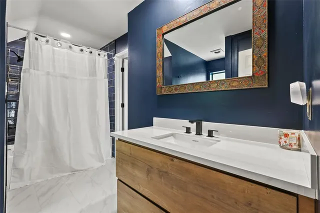 a bathroom with a granite countertop sink mirror and a bathtub