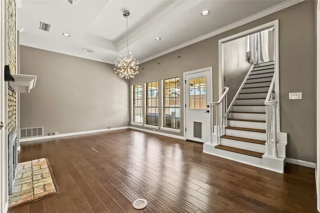 a view of a hallway with wooden floor and a livingroom
