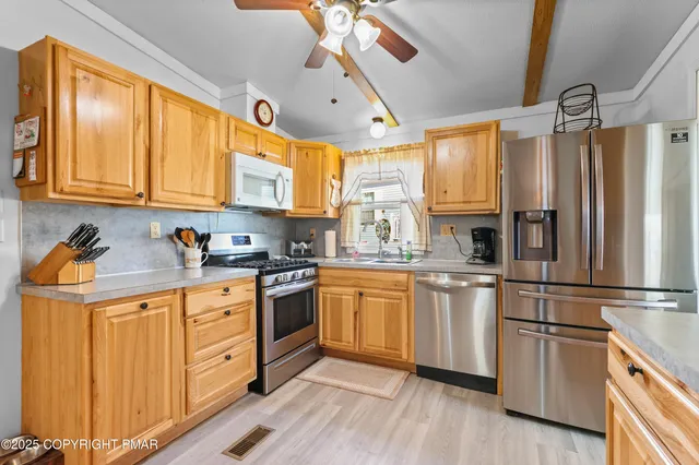 a kitchen with granite countertop a sink stainless steel appliances and cabinets