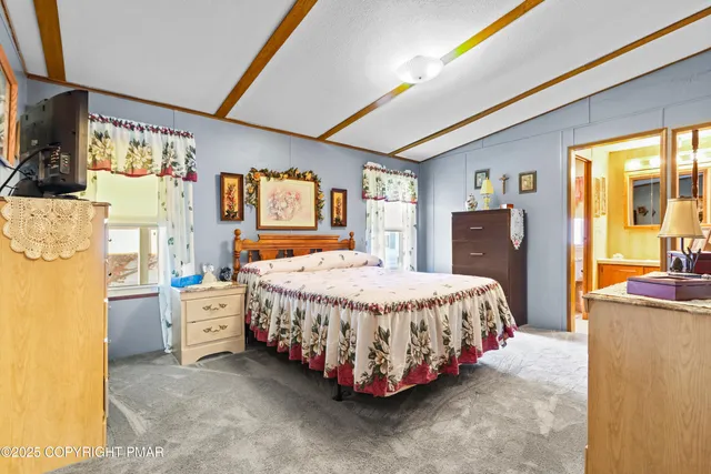 a bed room with a bed and a flat tv screen