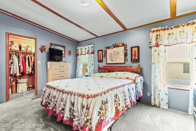 a bedroom with a bed window and flat screen tv