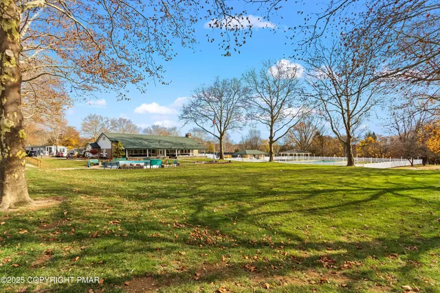 a view of swimming pool with outdoor seating and trees in the background