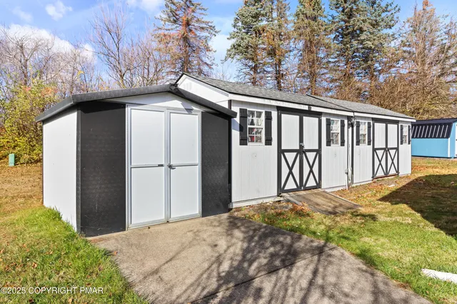 a white house that has tree in front of it