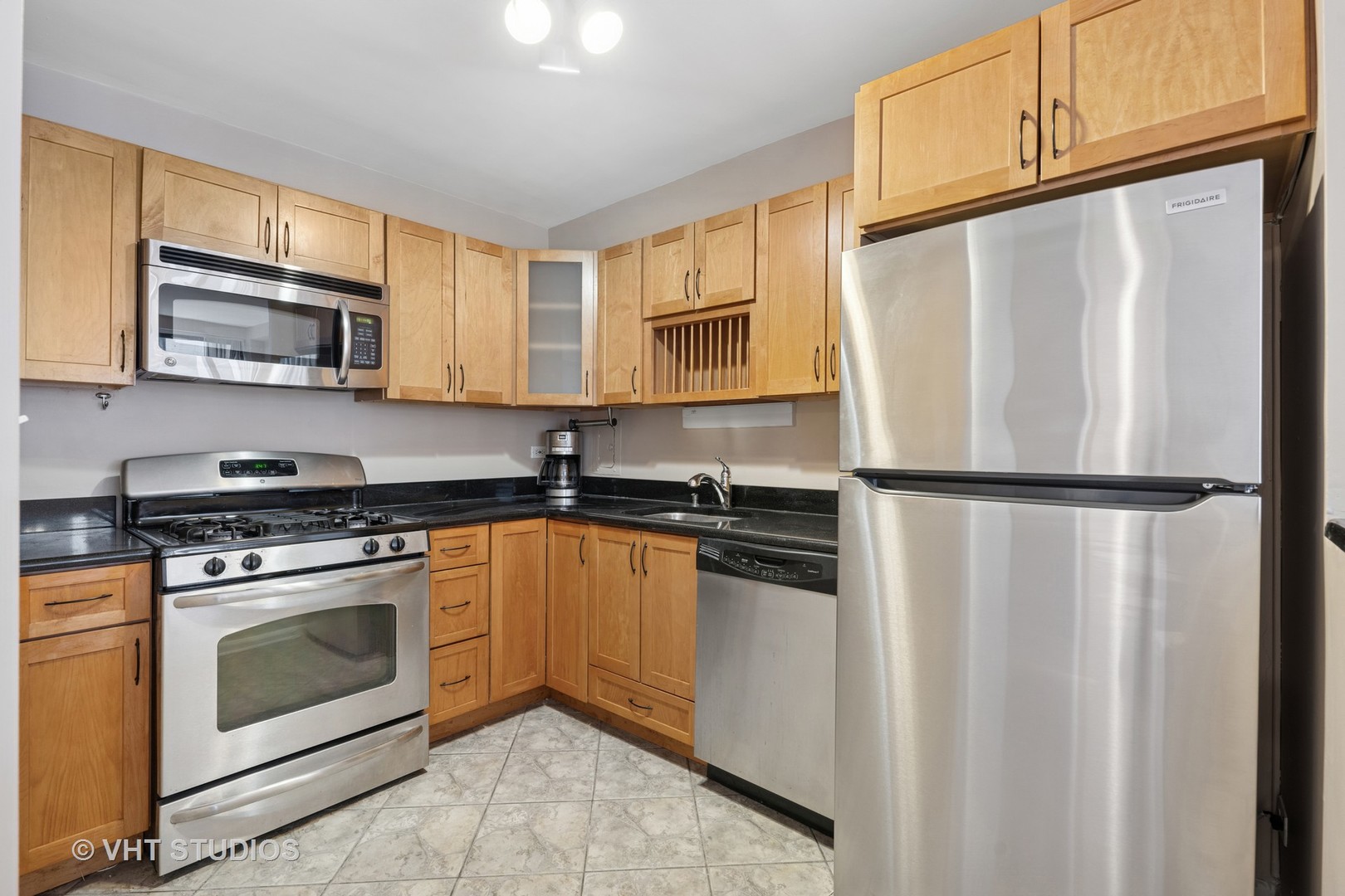 850 North Dewitt Place, Unit 11D Chicago, IL 60611 - Photo 4 of 15 a kitchen with stainless steel appliances granite countertop a refrigerator sink stove microwave and cabinets