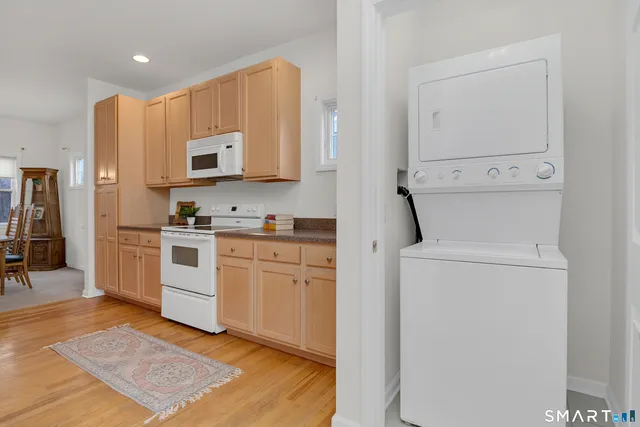 a kitchen with cabinets stainless steel appliances and wooden floor