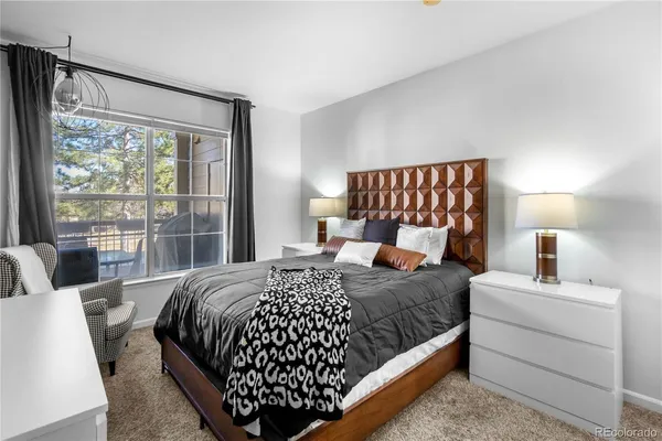 a bedroom with a large bed and a lamp next to a window