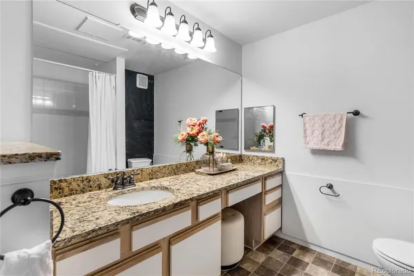 a bathroom with a granite countertop sink a large mirror and vanity