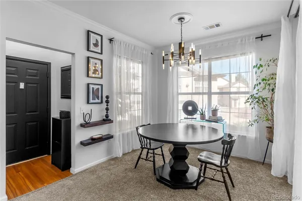 a dining room with furniture a chandelier and window