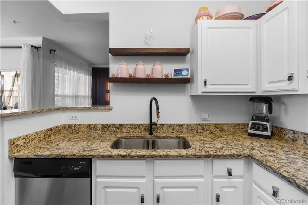 a kitchen with granite countertop a sink and cabinets