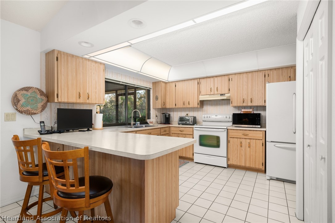 5802 Golden Road Sebring, FL 33875 - Photo 11 of 37 a kitchen with a stove a sink and a refrigerator