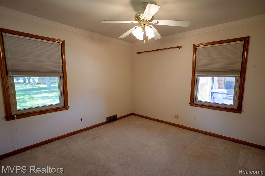 33033 Edgegrove Road Fraser, MI 48026 - Photo 14 of 20 Carpeted room featuring two windows with blinds, crown molding, and a ceiling fan with integrated lighting