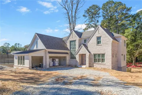 a front view of a house with a garden and tree
