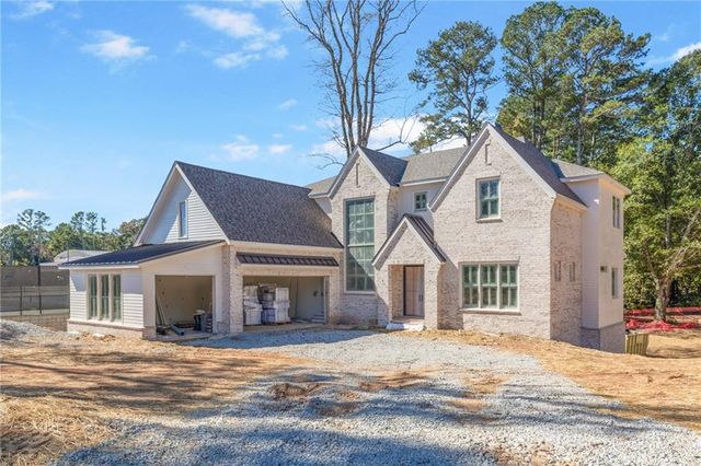 a front view of a house with a garden and tree