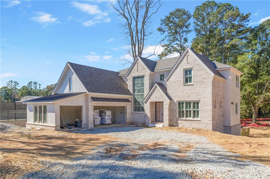 10908 Woodstock Road Roswell, GA 30075 - Photo 3 of 20 a front view of a house with a garden and tree