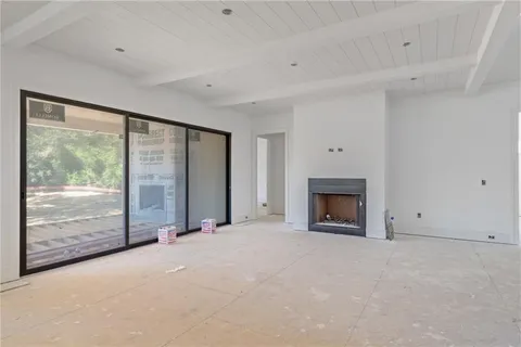 a view of an empty room with a fireplace and a window
