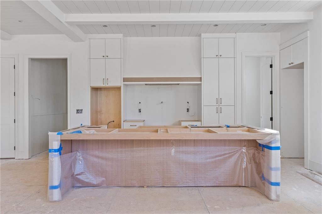 10908 Woodstock Road Roswell, GA 30075 - Photo 8 of 20 a room with kitchen island stainless steel appliances a sink and cabinets