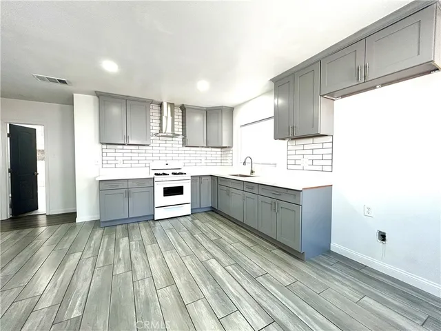 a kitchen with a sink wooden floor and a stove