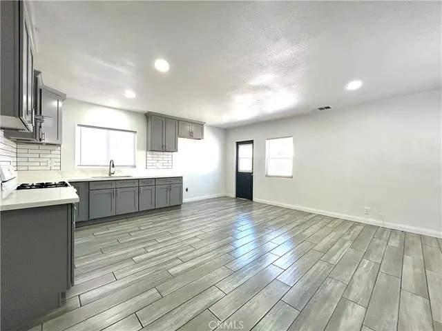 a view of a kitchen with wooden floor and a sink