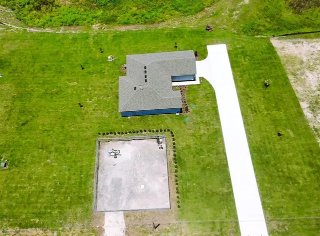 an aerial view of a house with a yard