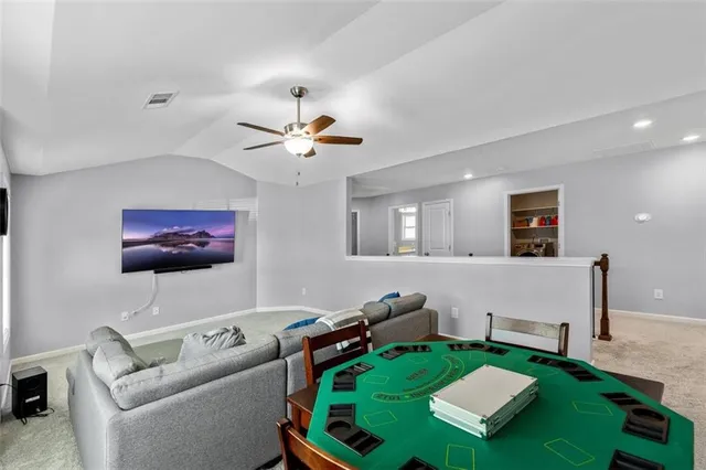 a living room with furniture a flat screen tv and a large window