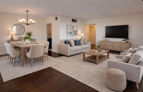 a living room with furniture chandelier and a flat screen tv