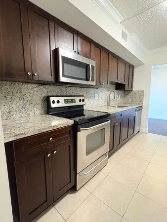 a kitchen with stainless steel appliances granite countertop wooden cabinets a stove top oven a sink and dishwasher