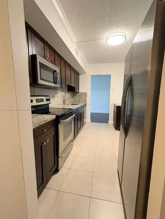 a kitchen with stainless steel appliances granite countertop a refrigerator and a stove top oven