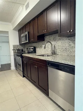 a kitchen with stainless steel appliances granite countertop wooden cabinets a sink and dishwasher