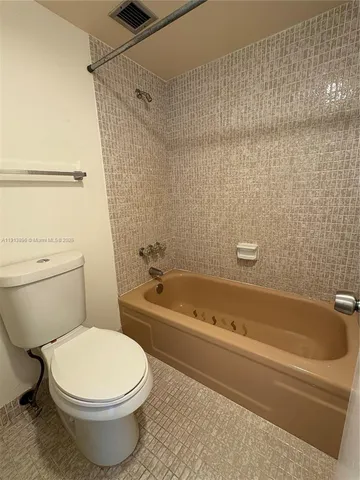 a bath room with a toilet and a bath tub