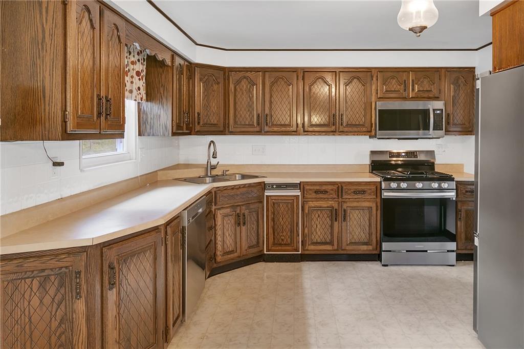 25 Pheasant Run Drive Export, PA 15632 - Photo 9 of 25 a kitchen with stainless steel appliances a stove sink microwave and cabinets