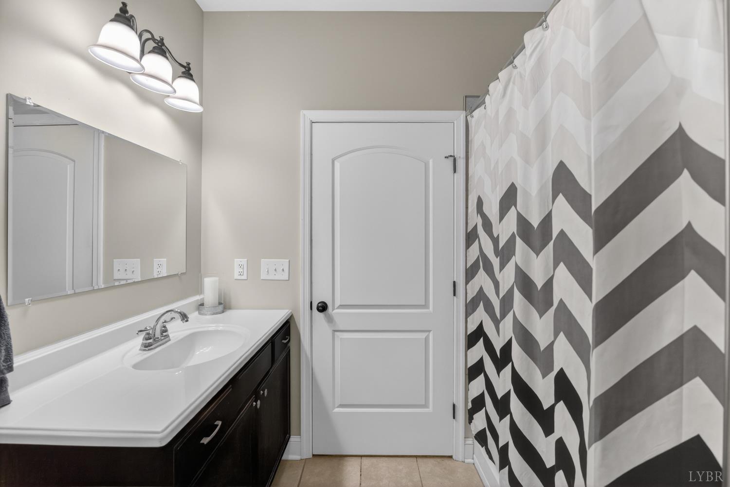 1198 Crest Ridge Drive Bedford, VA 24523 - Photo 17 of 40 a bathroom with a sink a mirror and a shower curtain