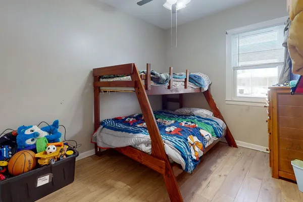 a bedroom with baby bed and a wooden floor