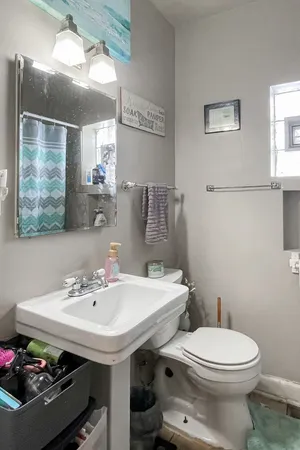 a bathroom with a sink mirror and toilet