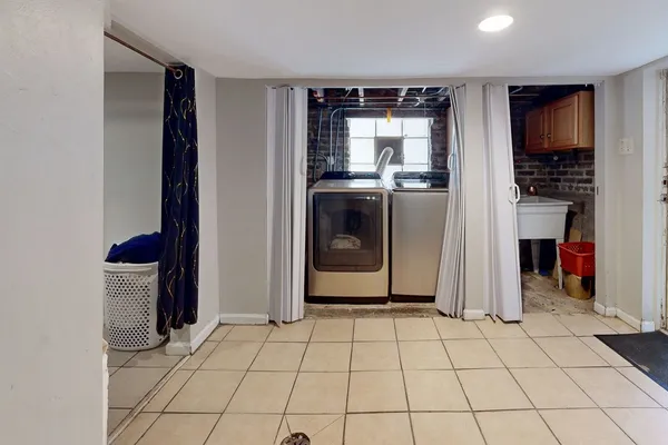 a view of a refrigerator in kitchen and an empty room