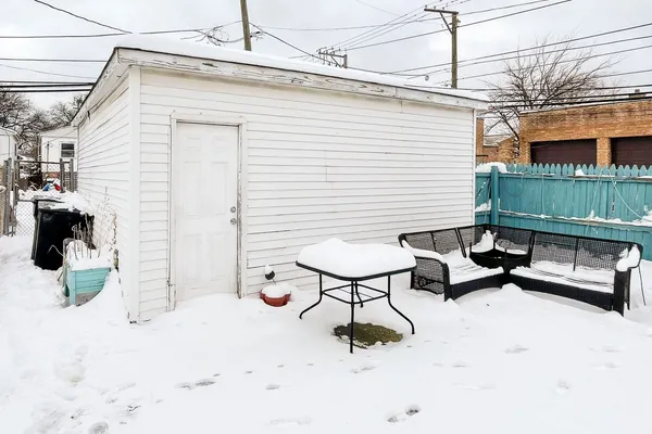 a backyard of a house with barbeque oven table and chairs