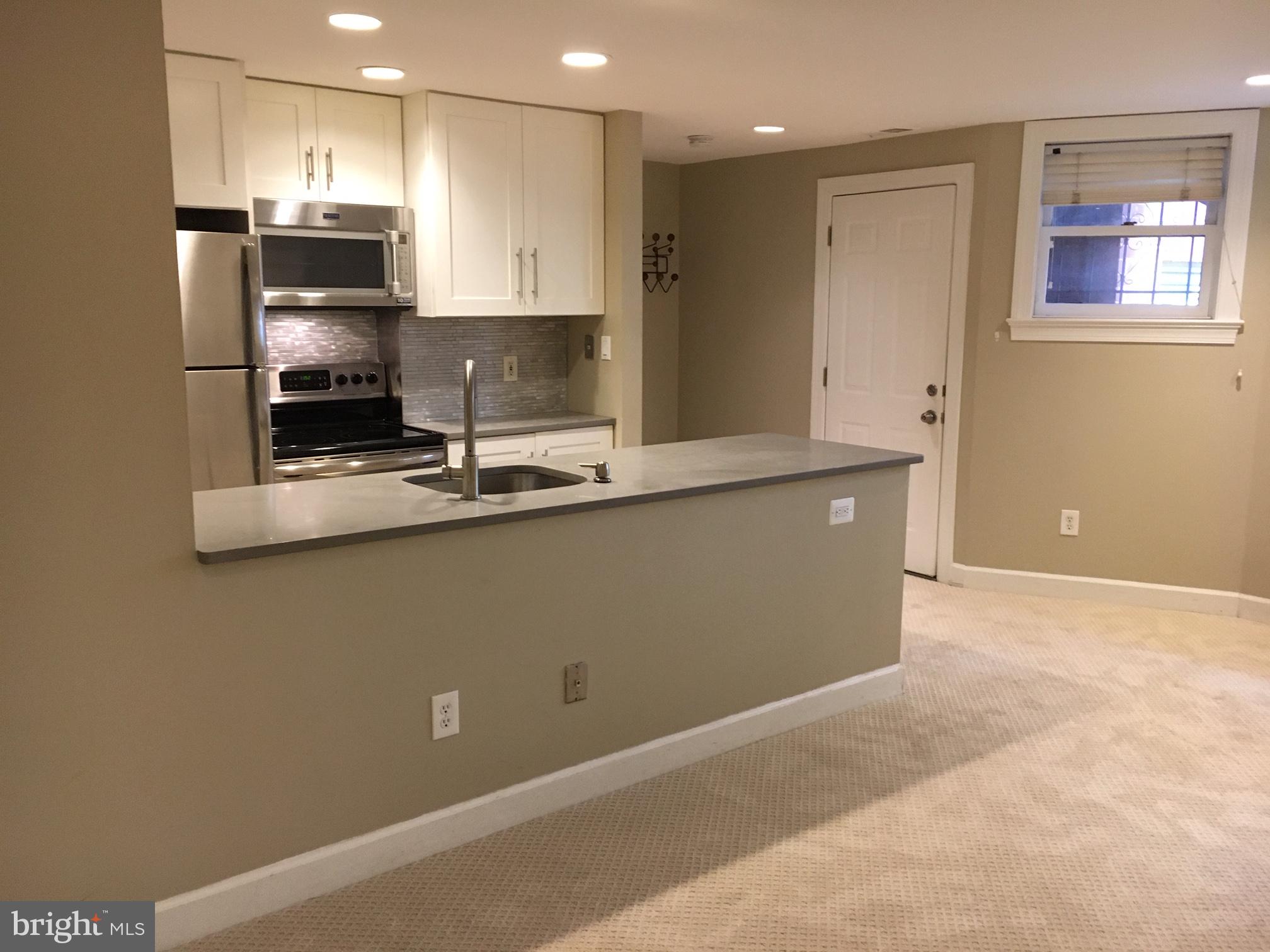 1630 19th Street Northwest, Unit B2 Washington, DC 20009 - Photo 7 of 19 a kitchen with kitchen island white cabinets and stainless steel appliances