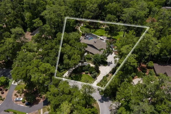 an aerial view of house with swimming pool and garden