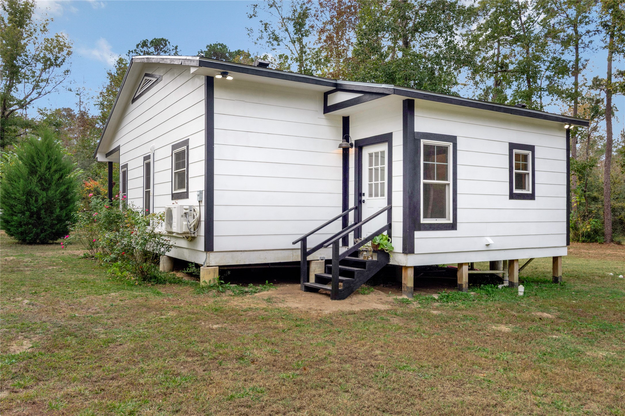 1080 Hill Road Willis, TX 77378 - Photo 24 of 33 a small white building with a white roof and table and chairs under an umbrella